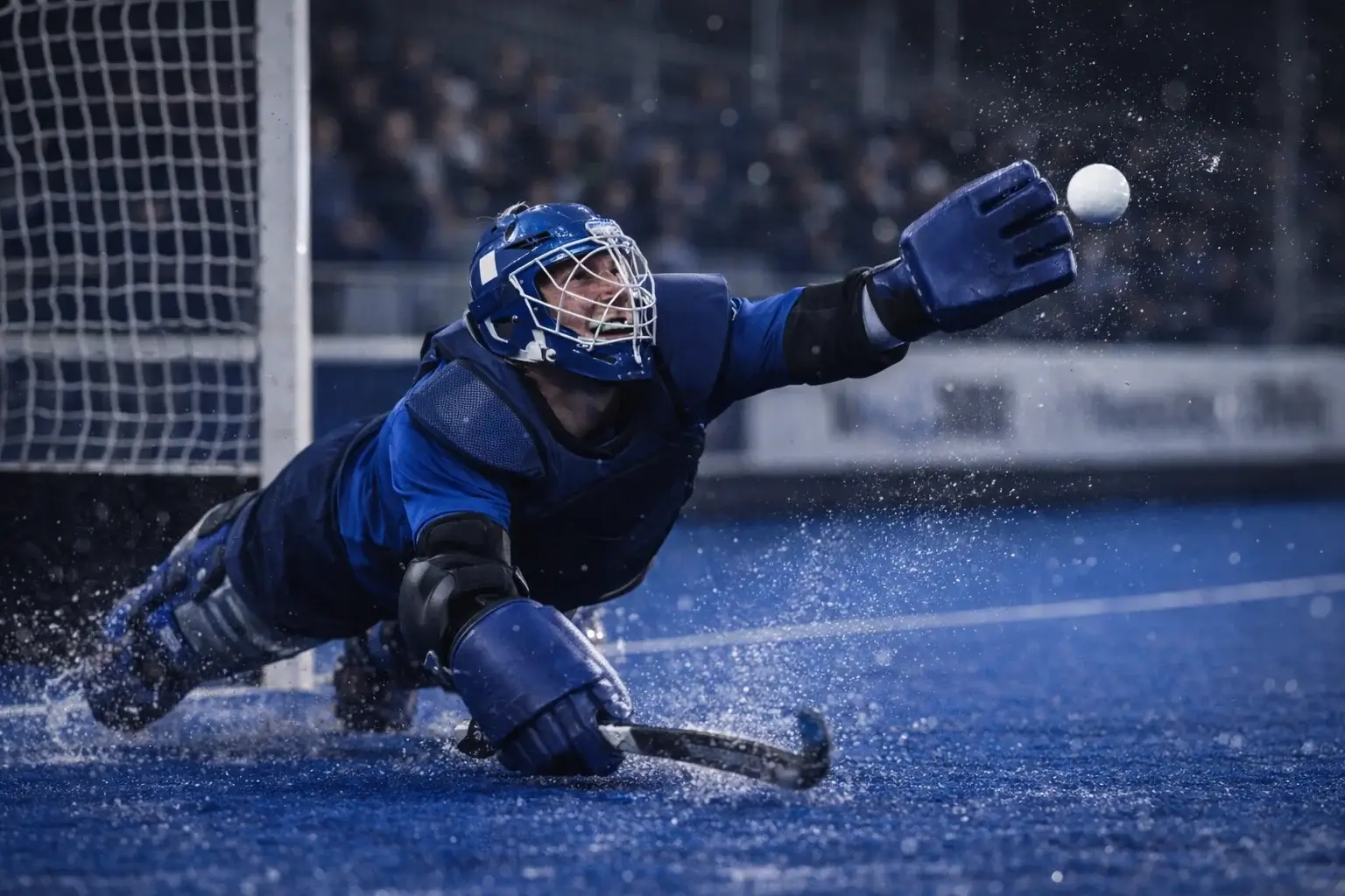 Keeper probeert een schot te stoppen tijdens een hockeywedstrijd