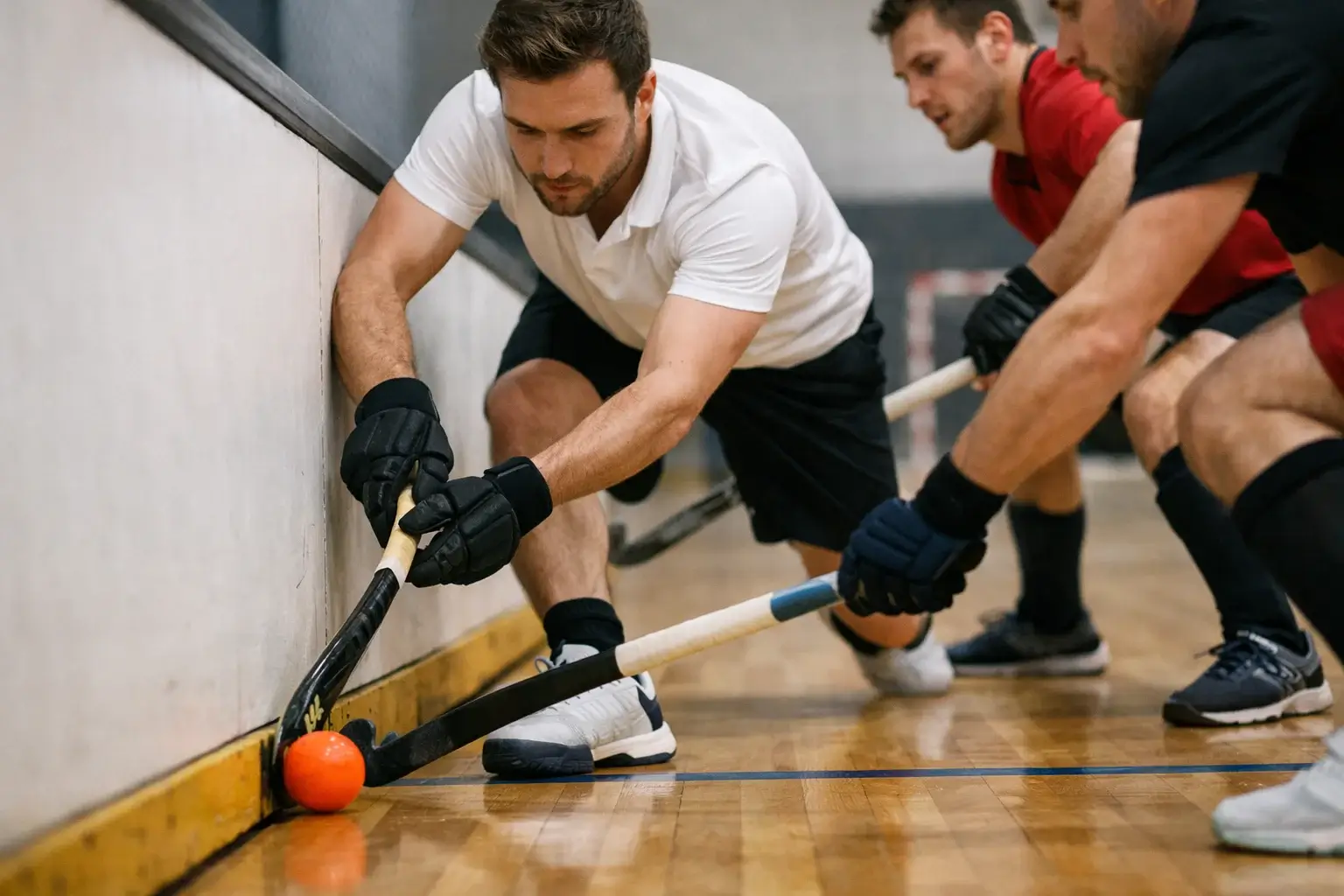 Technische actie tijdens een zaalhockeywedstrijd met boarding zichtbaar